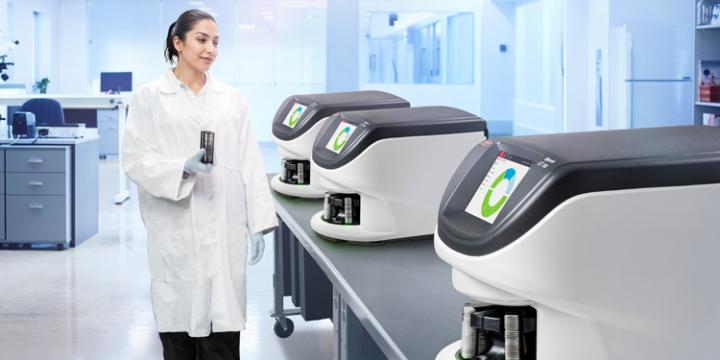 Female histology lab employee prepares to load a slide rack into the Aperio GT 180 digital pathology slide scanner.